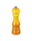 A yellow-to-orange gradient pepper mill with a silver metal top, centered on a plain white background.