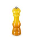 A yellow to orange gradient pepper mill with a silver metal top, centered on a plain white background.