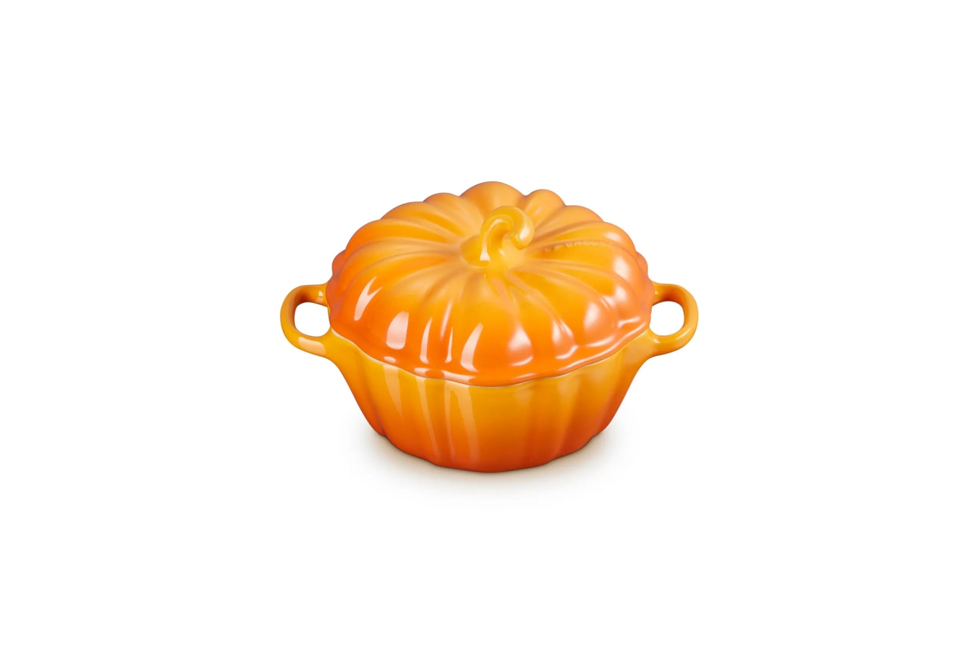 A persimmon cast iron pumpkin-shaped lidded cocotte dish with side handles, shown on a solid white background.