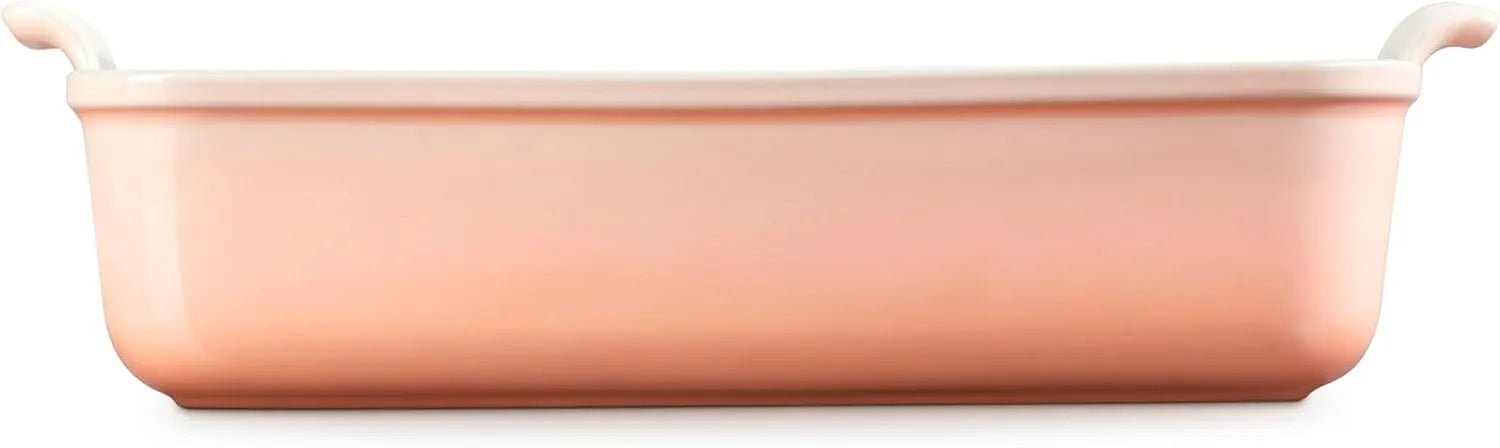 Side view of a peach rectangular baking casserole dish with two small loop handles on the sides, shown from a front-facing perspective on a solid white background.