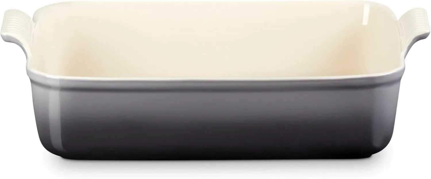 A rectangular ceramic baking dish with a dark gray to off-white gradient design, featuring a cream-colored interior and side handles, shown on a plain white background.