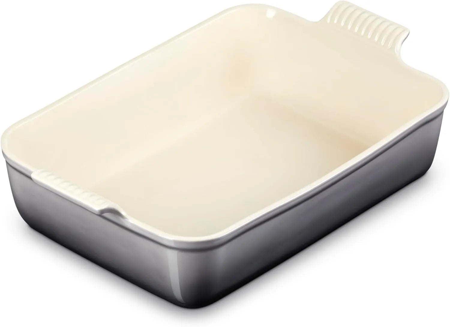 A rectangular baking dish with a cream-colored interior and a dark gray exterior, featuring integrated side handles with ribbed grips.