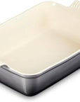 A rectangular baking dish with a cream-colored interior and a dark gray exterior, featuring integrated side handles with ribbed grips.