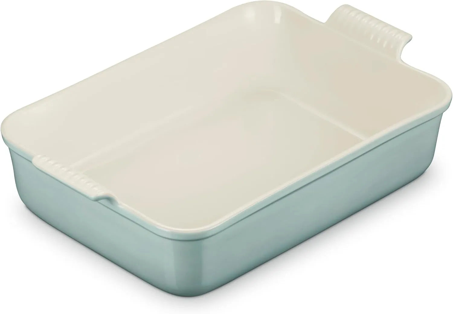 A rectangular ceramic baking dish with a light green exterior and a cream-colored interior, featuring integrated side handles.