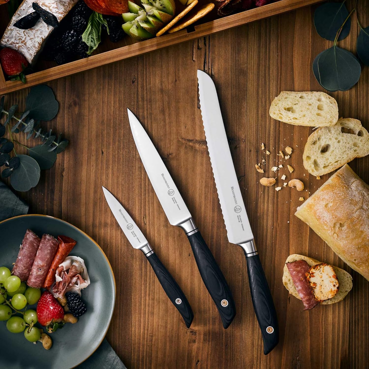 Set of knives on a wooden surface with food items