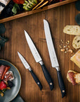 Set of knives on a wooden surface with food items
