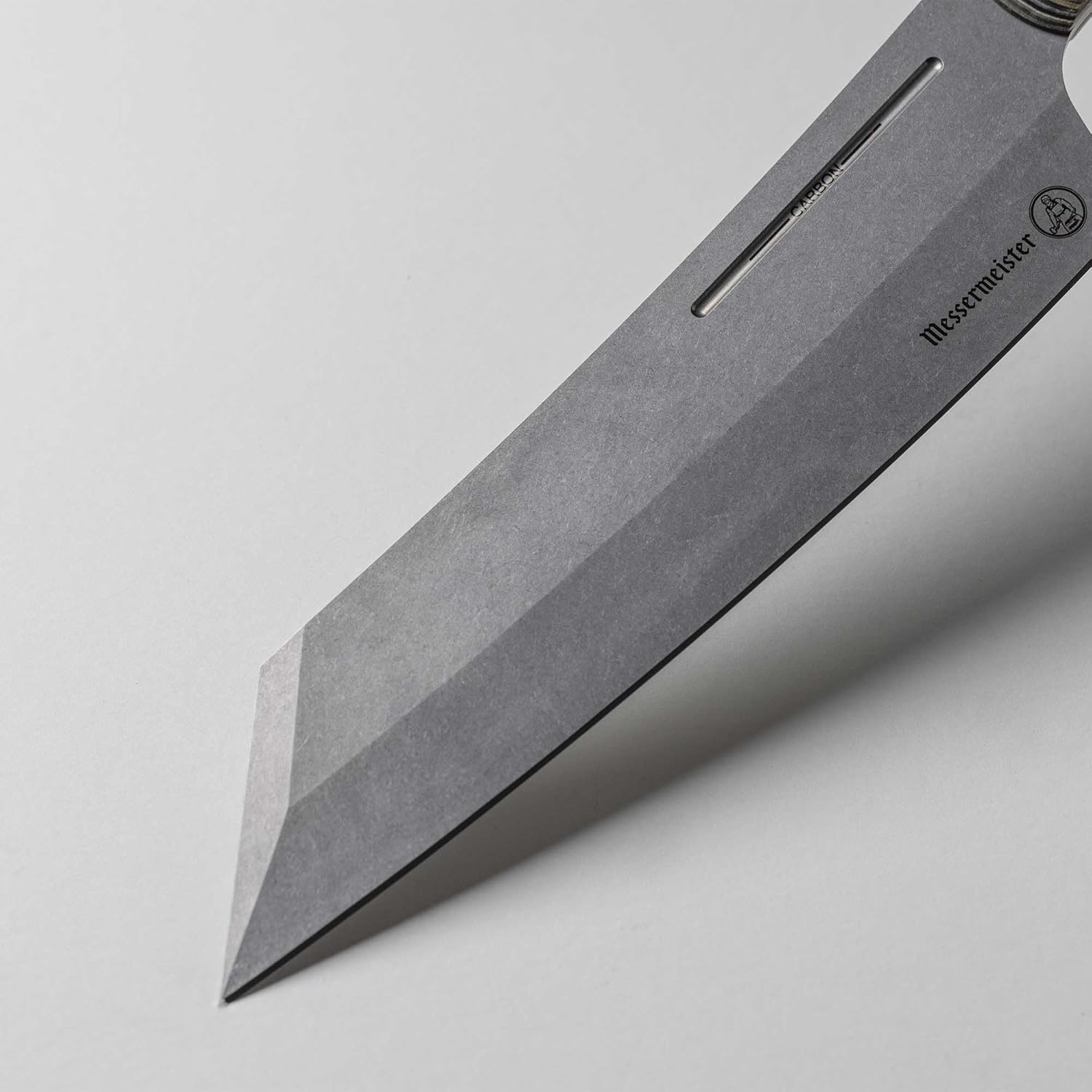 Close-up of a knife blade with Messermeister branding on a light gray background