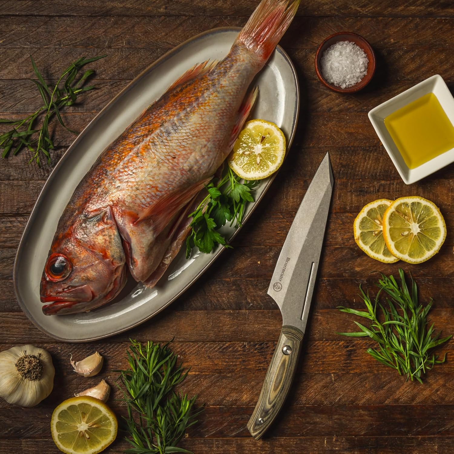Raw fish on a plate with lemon slices, herbs, and a knife on a wooden surface