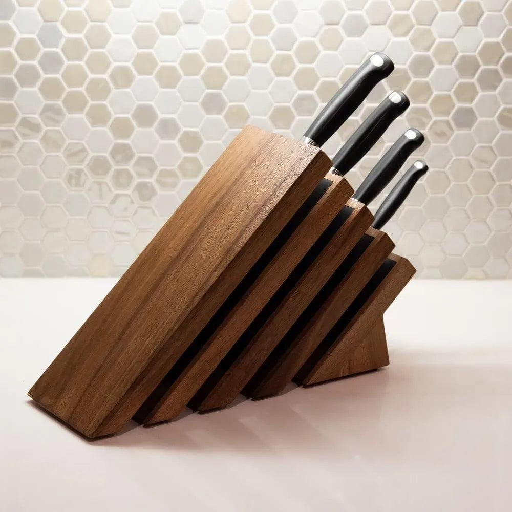 Set of knives in a wooden block on a kitchen counter with a tiled backsplash.