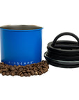 Matte blue airscape container with coffee beans and black lid on a white background