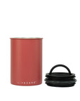Red cylindrical container with black lid on a white background