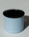 Light blue container with black lid on a white background