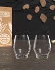 Two clear glass tumblers with a box labeled 'Bourbon' on a dark surface.