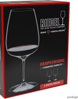 Riedel wine glass packaging with a glass of red wine on a black background