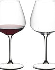 Two wine glasses, one filled with red wine, on a white background