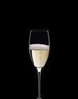 A single clear champagne flute filled with pale golden bubbly liquid, centered on a solid black background.