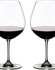Two clear stemmed wine glasses filled with red wine, shown side by side on a plain white background.