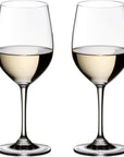 Two clear stemmed wine glasses filled with white wine, shown side by side on a plain white background.