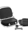 Black and silver grill with an assortment of attachments on a white background