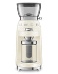 SMEG coffee grinder in cream with silver accents and a clear bean hopper, shown on a solid white background.
