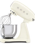 Cream-colored stand mixer slanted open with whisk attachment on a white background