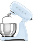Light blue Smeg stand mixer slanted open with a mixing bowl on a white background