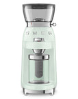 Front view of Mint green coffee grinder with glass container on a white background