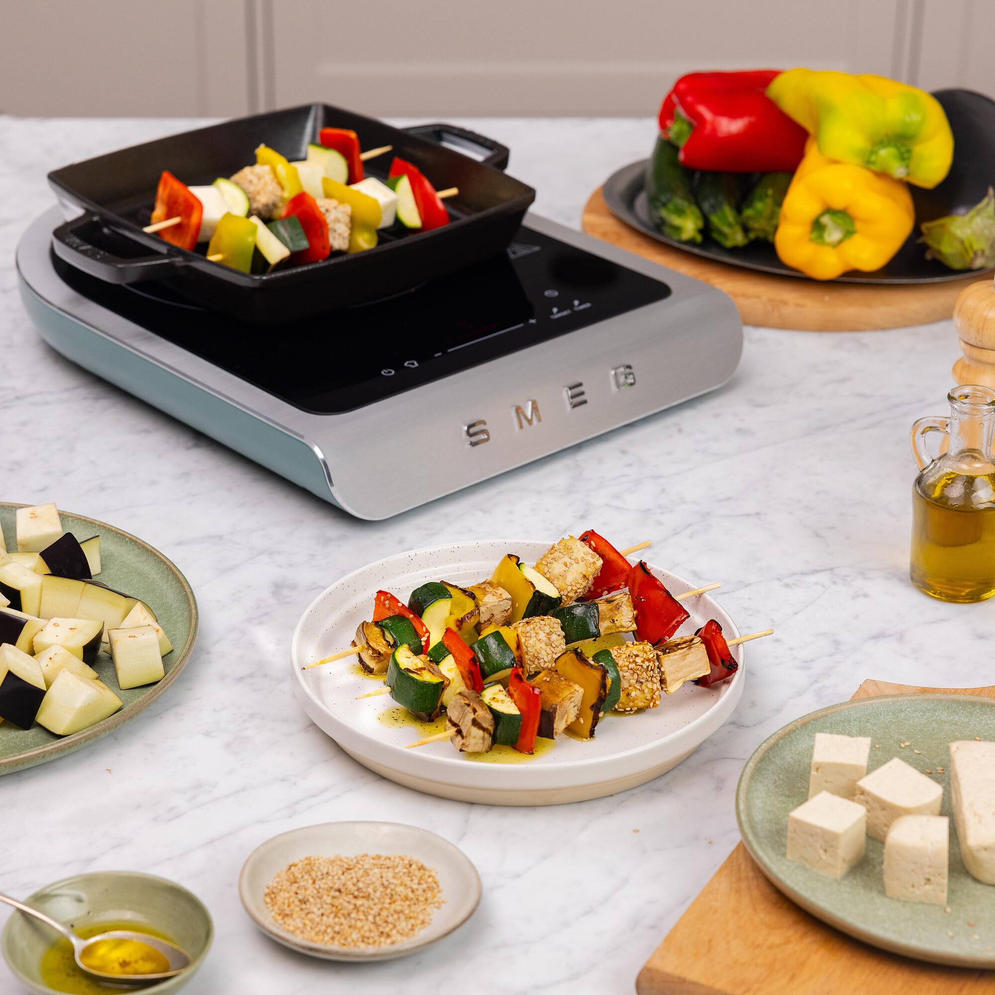 Smeg electric induction top  with skewered vegetables and ingredients on a kitchen counter