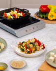 Smeg electric induction top  with skewered vegetables and ingredients on a kitchen counter