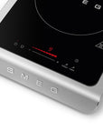 Induction cooktop with digital display and SMEG branding on a white background