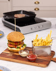 Burger and fries on a kitchen counter with a Smeg induction cooker in the background
