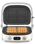 Cream Smeg grill with silver accents with cooked waffles on a white background