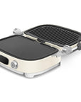 Cream Smeg grill with silver accents open on a white background