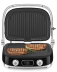 Black Smeg grill with two steaks on a white background