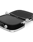 Black Smeg grill with silver accents opened on a white background