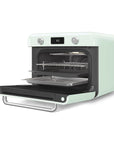 Pastel green Smeg retro line countertop air fry oven with door open with baking sheets on a white background