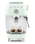 Pastel green Smeg espresso machine with two cups of coffee on a white background