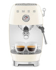 Cream-colored Smeg espresso machine with two glass cups of coffee on a white background