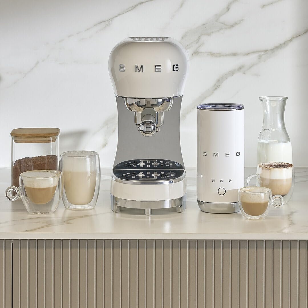 White Smeg coffee machine on a kitchen counter with various coffee items.