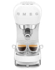 White SMEG espresso machine with two glass cups with coffee inside on a white background