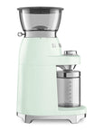 Side view of a retro-style electric coffee grinder in pale mint green with silver and black accents, featuring a clear hopper, bean hopper lid, and clear collection container on a white background.