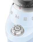 Close-up of a vintage-style coffee grinder with 'Smeg' branding with a dial on a white background