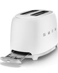 White toaster with SMEG logo with drawer open on a white background