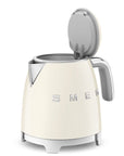 Smeg cream-colored kettle with metallic accents and lid open on a white background