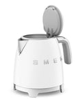White electric kettle with open lid on a white background, featuring the Smeg logo.