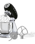 Black and silver stand mixer with attachments on a white background