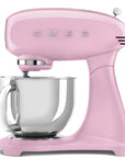 Pink Smeg stand mixer with mixing bowl on a white background