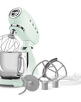 Light green stand mixer with attachments on a white background