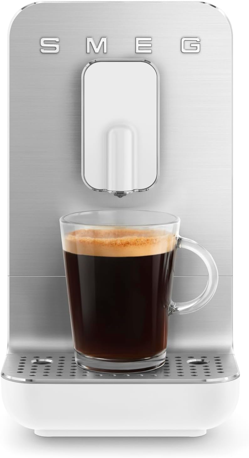 White SMEG espresso machine with a glass of espresso on a white background