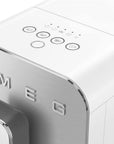 Close-up of a Smeg coffee maker with control panel and logo.